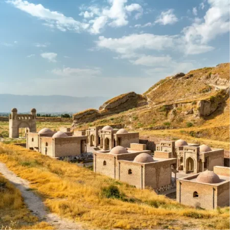 Ancient stone ruins in Tajikistan overlooking a remote valley on the 5 Stans Tour.
