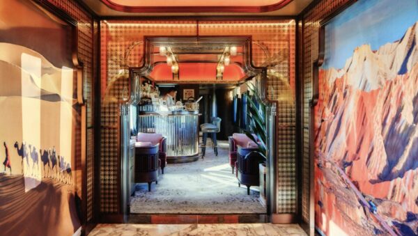 The luxurious interior of the Orient Silk Road Express train carriage in Uzbekistan, featuring ornate wood carvings, plush seating, and elegant traditional decor.