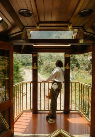 The luxurious interior of the Hiram Bingham train to Machu Picchu, showcasing classic wood panels and large windows overlooking the scenic Sacred Valley.